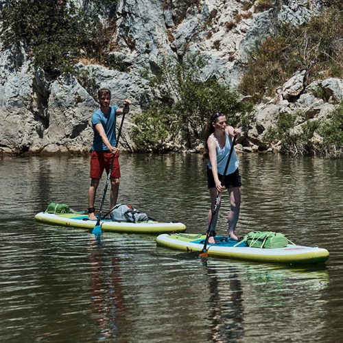 two people paddle boarding in a canyon