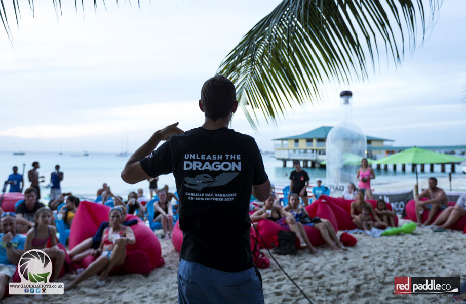 man on mic talks to teams on the beach