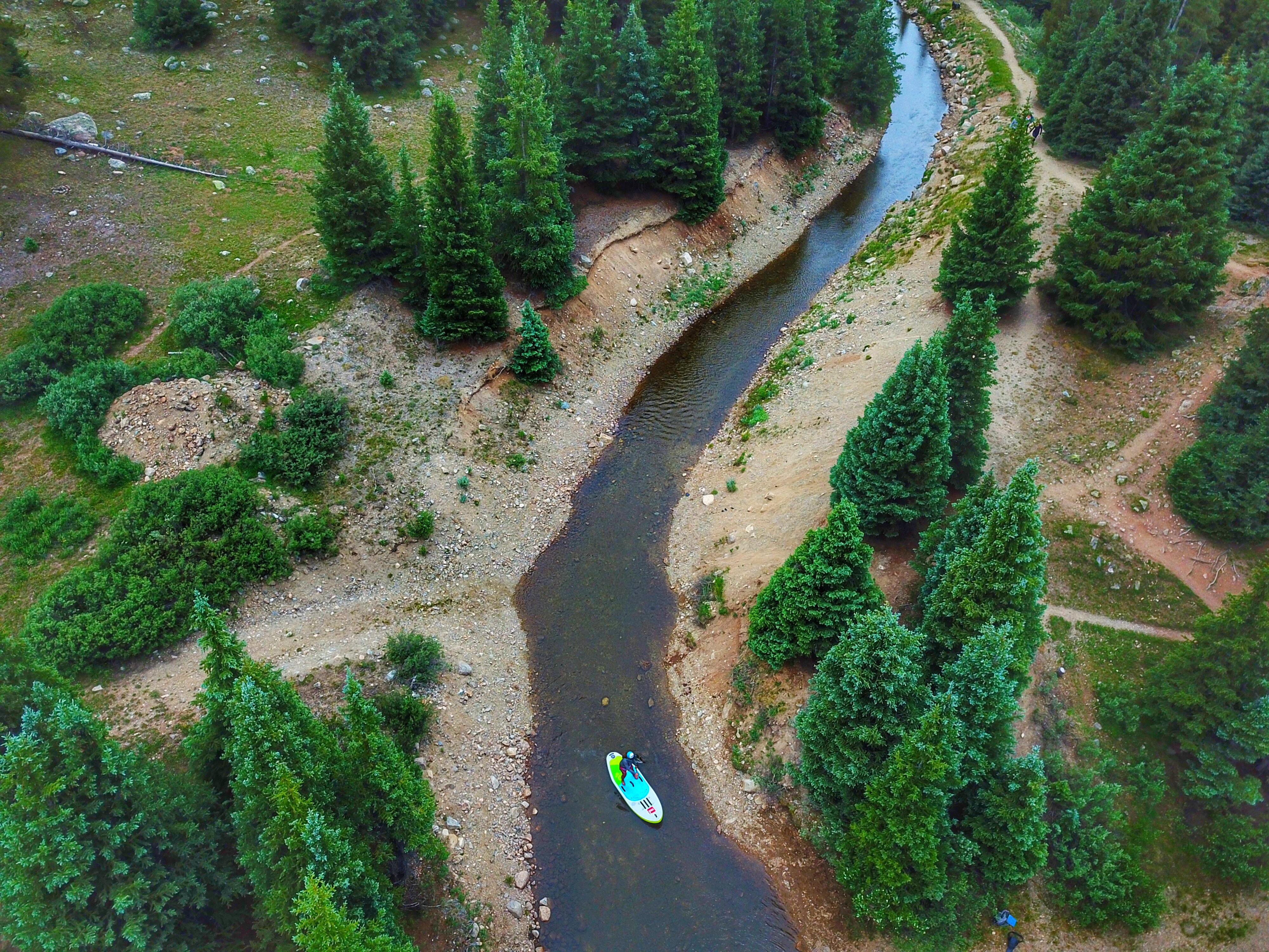 Jordan Paddles down a river on a stand up paddle board.