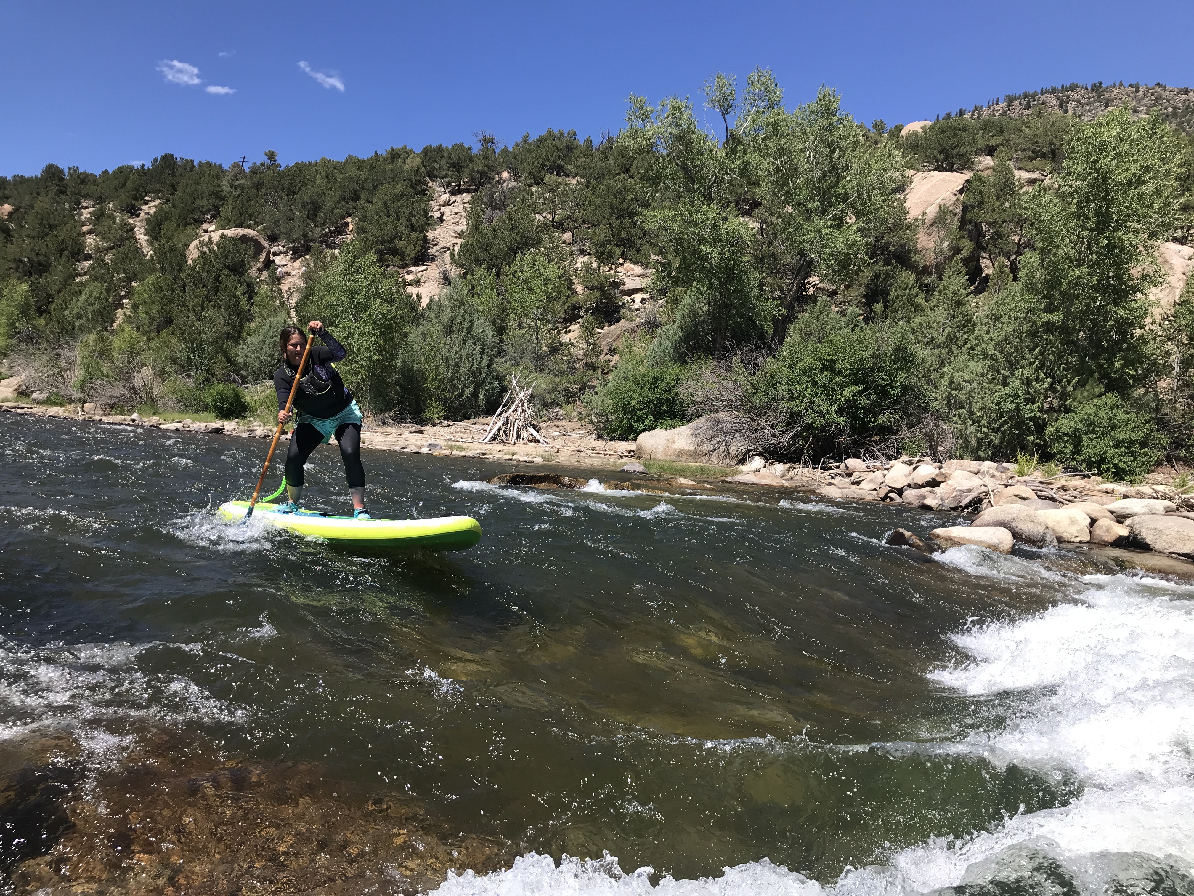 Women paddling whitewater river on Stand up Paddle board 