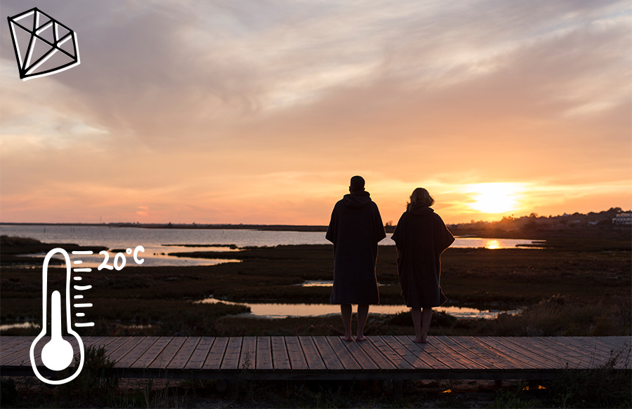 Couple stand and watch sunset