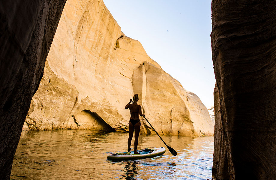 silhouette on girl on SUP next to canyon