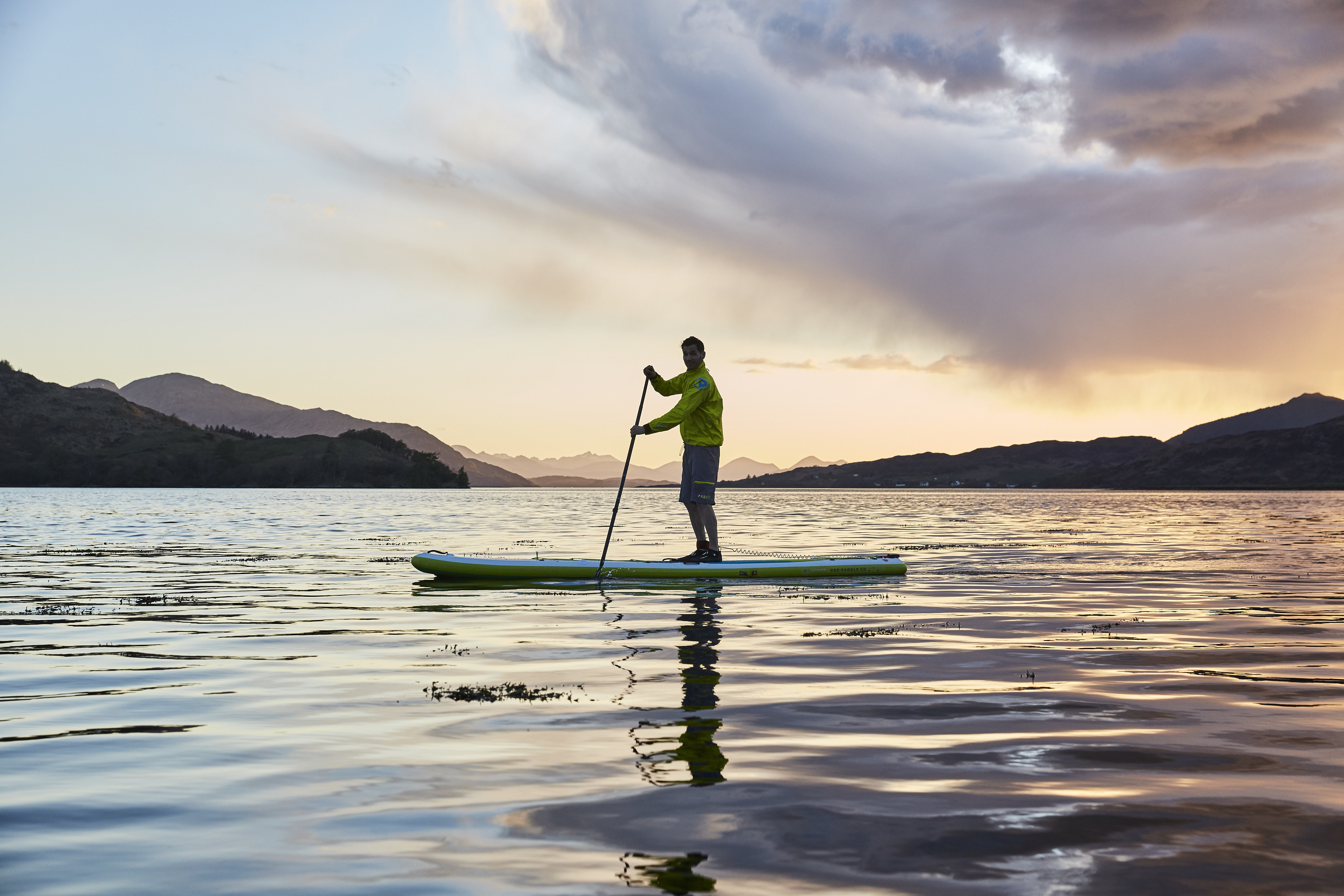 A loan paddle boarder paddling at sunset, Isle of Skye