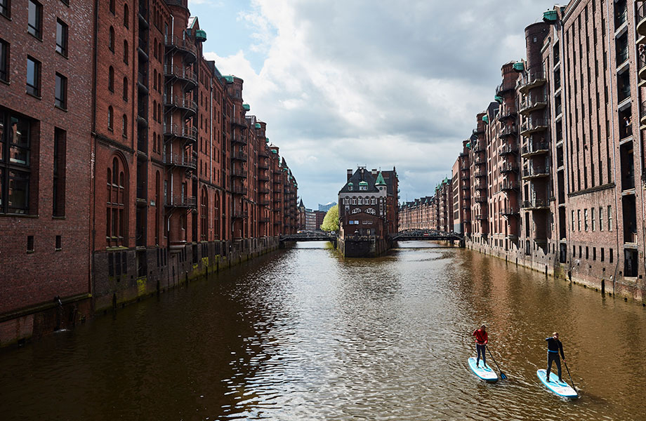 two paddle boarders in Hamburg on canal. 