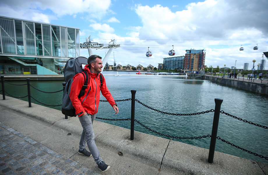 man walks with inflatable SUP backpack on his back